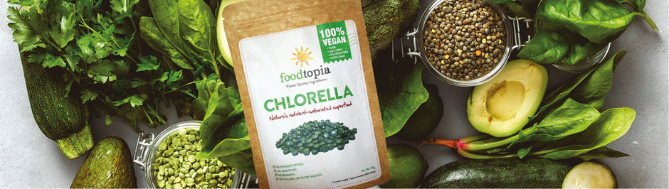 pack of chlorella tablets on background of green vegetables